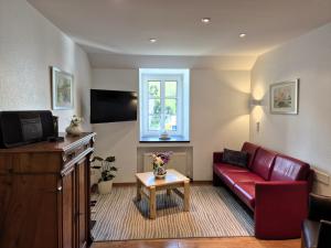 a living room with a red couch and a tv at Feriengut Bohn in Bernkastel-Kues