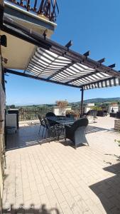 a patio with a table and chairs under a pergola at Residence Villa Savoia in Marino