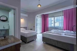 two beds in a room with a bathroom at Best Alanya Hotel in Alanya +43 photos