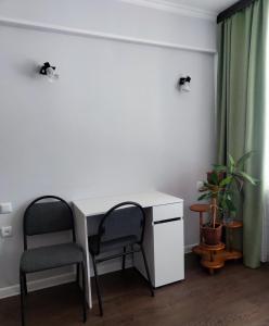a white desk and two chairs in a room at Сдается квартира у Озера in Balqash +3 photos