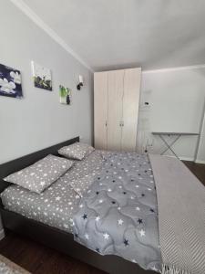 a bedroom with a bed and a white wall at Сдается квартира у Озера in Balqash
