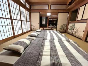 a large bed in a room with large windows at 373アルプスの風 - 最大11名 in Minami Alps