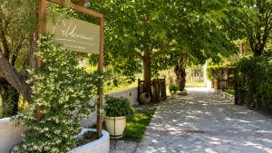 a sign for a garden with trees and a sidewalk at Calderimi Lefkada in Nydri