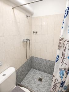 a bathroom with a shower with a toilet and a shower curtain at Pfaffenhofen in Nea Vrasna