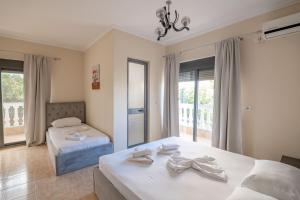 a bedroom with two beds and a window at Hotel Primavera in Sarandë