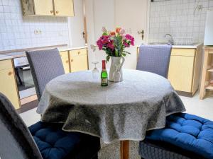 a table with a bottle of wine and flowers on it at Zum Häusler-Glück in Biendorf