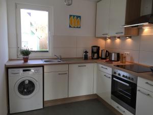 a kitchen with a washing machine and a sink at Strandläufer in Breege