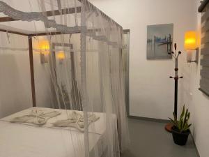 a bedroom with a canopy bed with white curtains at Kingly Aroma in Arugam Bay