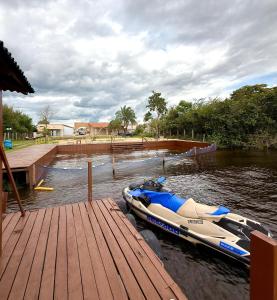 a boat parked on the water next to a dock at Casabela - Summer Ville - Lençóis Maranhenses in Barreirinhas