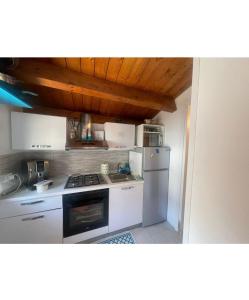 a kitchen with a stove and a refrigerator at Sweet NiMa in Francavilla al Mare