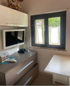 a living room with a tv and a dresser with a tvicter at Sweet NiMa in Francavilla al Mare