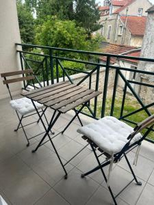 two chairs and a wooden bench on a balcony at appartement cosy tout équipe in Épinay-sur-Orge
