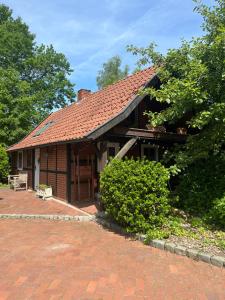 a house with a red roof on a brick driveway at Ferienhaus in Rumke in Bippen