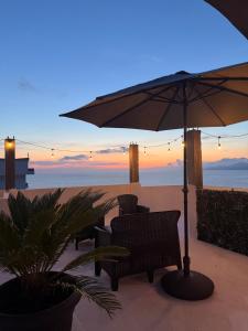 a patio with an umbrella and chairs on the beach at Apartments and Studios Anicic in Utjeha