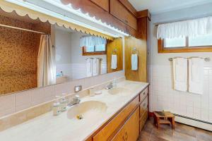 a bathroom with two sinks and a large mirror at Rainbow Riverhouse in South Fork +37 photos