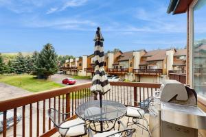 a balcony with a table and chairs and an umbrella at Beaver Creek Bungalow in Edwards