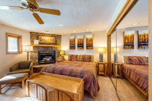 a bedroom with two beds and a couch and a fireplace at Togowotee 108 in Copper Mountain