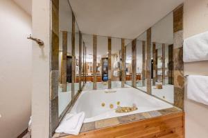 a bathroom with a tub with a large mirror at Togowotee 108 in Copper Mountain +123 photos