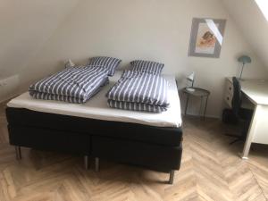 a bed with two pillows on it in a bedroom at Ribe Dankirke Bed & Kitchen in Ribe +6 photos