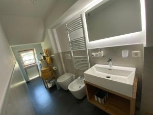 a bathroom with a white sink and a toilet at Villa Alessandra in Colle Isarco +26 photos