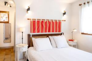 a bedroom with a white bed with red accents at Villa Lazuel, piscine privée chauffée, vue panoramique et jardin clos in Aubenas +37 photos