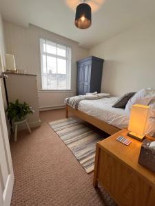 a bedroom with a bed and a table with a laptop on it at Cheerful and spacious 3 bed home in Clitheroe in Clitheroe