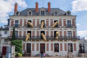 a building with a bunch of cat statues on it at L etoile bleue in Fossé