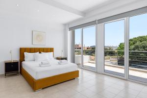 a bedroom with a bed and large windows at Celestial Luxury Residences in Ixia