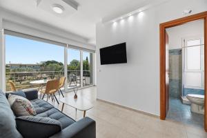 a living room with a couch and a tv at Celestial Luxury Residences in Ixia