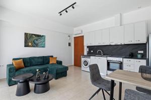 a living room with a green couch and a kitchen at Celestial Luxury Residences in Ixia