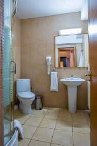 a bathroom with a toilet and a sink and a mirror at Hotel Maria in Rădăuţi