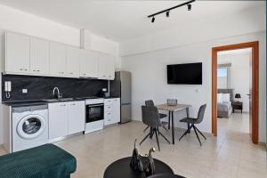 a kitchen and living room with a table and chairs at Celestial Luxury Residences in Ixia +4 photos