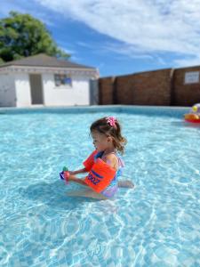 a little girl playing in a swimming pool at Beach Chalet Home in Scratby