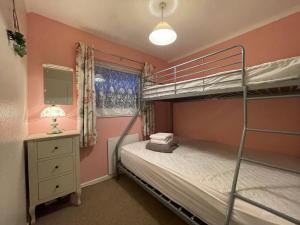 a bedroom with two bunk beds and a lamp at Beach Chalet Home in Scratby