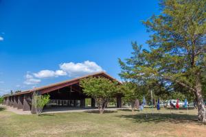 un edificio en un parque con árboles delante de él en Lake Texoma Camping Resort Cabin 17, en Willow Spring