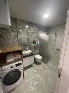 a bathroom with a washing machine and a toilet at AC Konaklama in Kuşadası +13 photos