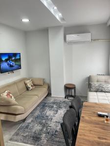 a living room with a couch and a table at AC Konaklama in Kuşadası