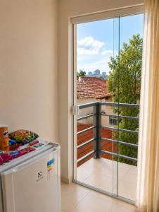a kitchen with a sliding glass door to a balcony at Pousada Yeshua in Paracatu +10 photos