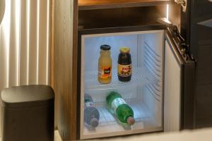 an open refrigerator with two bottles of drinks in it at Una Rooms in Poreč