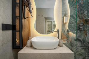 a bathroom with a sink in front of a mirror at Una Rooms in Poreč +74 photos