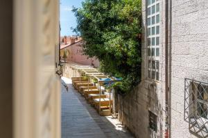 an alley with chairs and umbrellas on a building at Una Rooms in Poreč