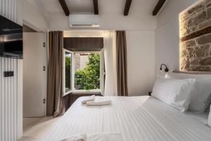 a bedroom with a large white bed with a window at Una Rooms in Poreč