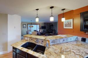 a kitchen with a marble counter top with a sink at Quaint Mountain Condo in Frisco +49 photos