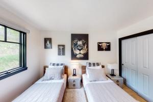 two beds in a room with a window at Beaver Creeks Meadows in Beaver Creek