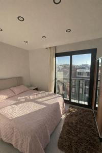 a bedroom with a bed and a large window at AC Konaklama in Kuşadası