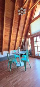 a table and chairs in a room with wooden ceilings at Cabaña Alpina Los Treiles in Panguipulli