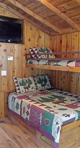 a room with two beds in a log cabin at Mount Vernon Camping Resort Studio Cabin 5 in Bow