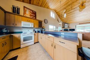 a large kitchen with wooden cabinets and a stove at Firelight Chalet 94 in Big Sky +46 photos