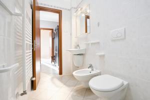 a white bathroom with a toilet and a sink at Villa Mapa - Appartamenti Lorusso in Vieste +110 photos