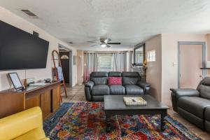 a living room with a couch and a flat screen tv at Bright 3BR, Dogs, Fenced Yard, FSU & Dwntown in Tallahassee